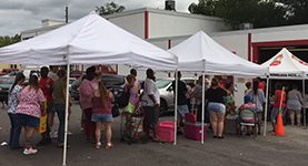 A group of people standing around an open tent.