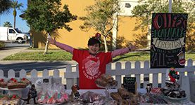A woman standing in front of some donuts.