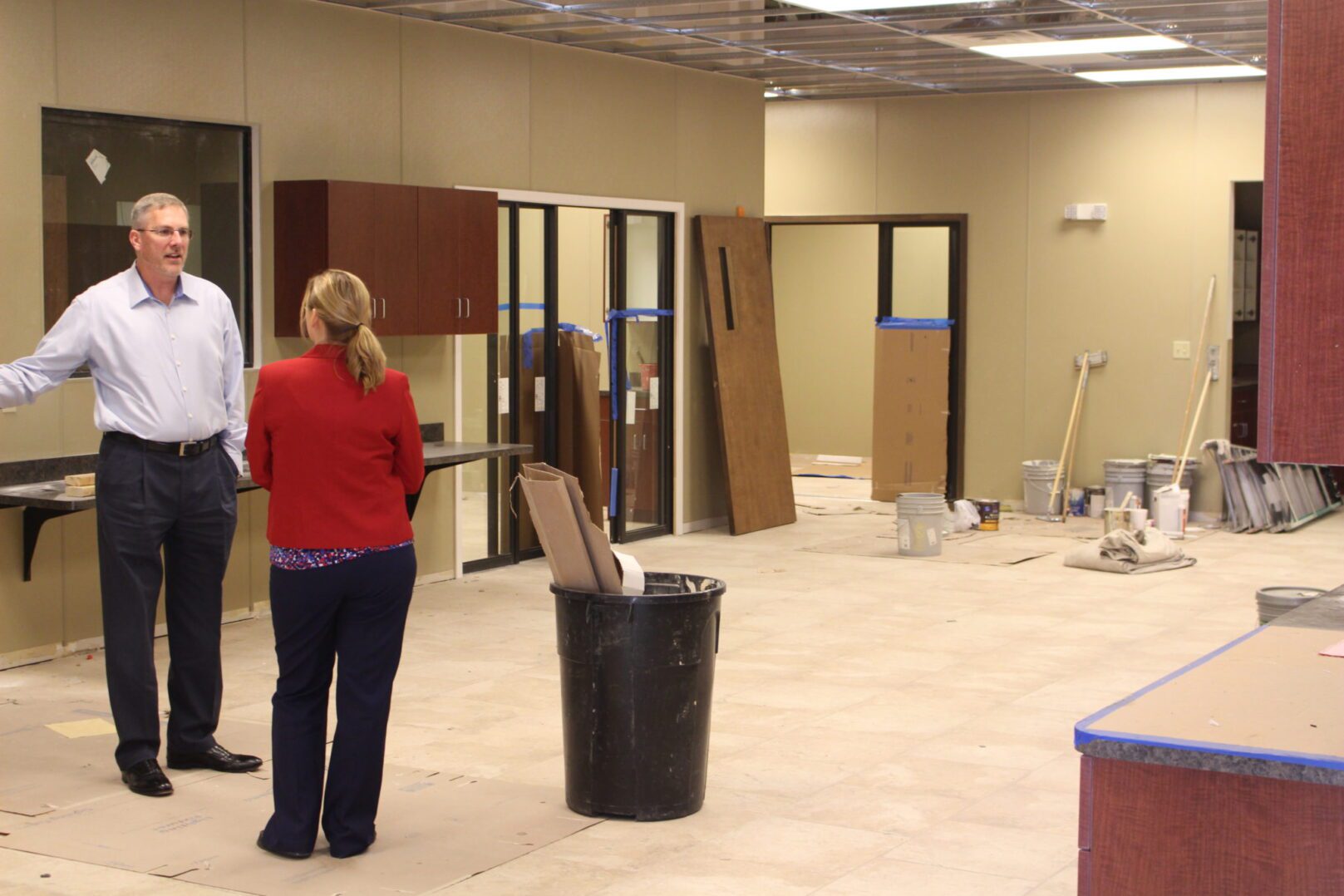 Two people standing in a room with some doors and walls