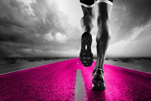 A person running on the road with pink paint.